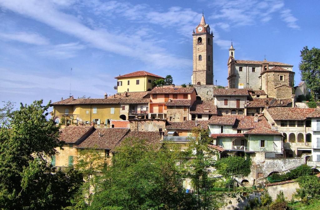 A historic town with a prominent clock tower, terracotta-roofed buildings, and a mix of architectural styles.
