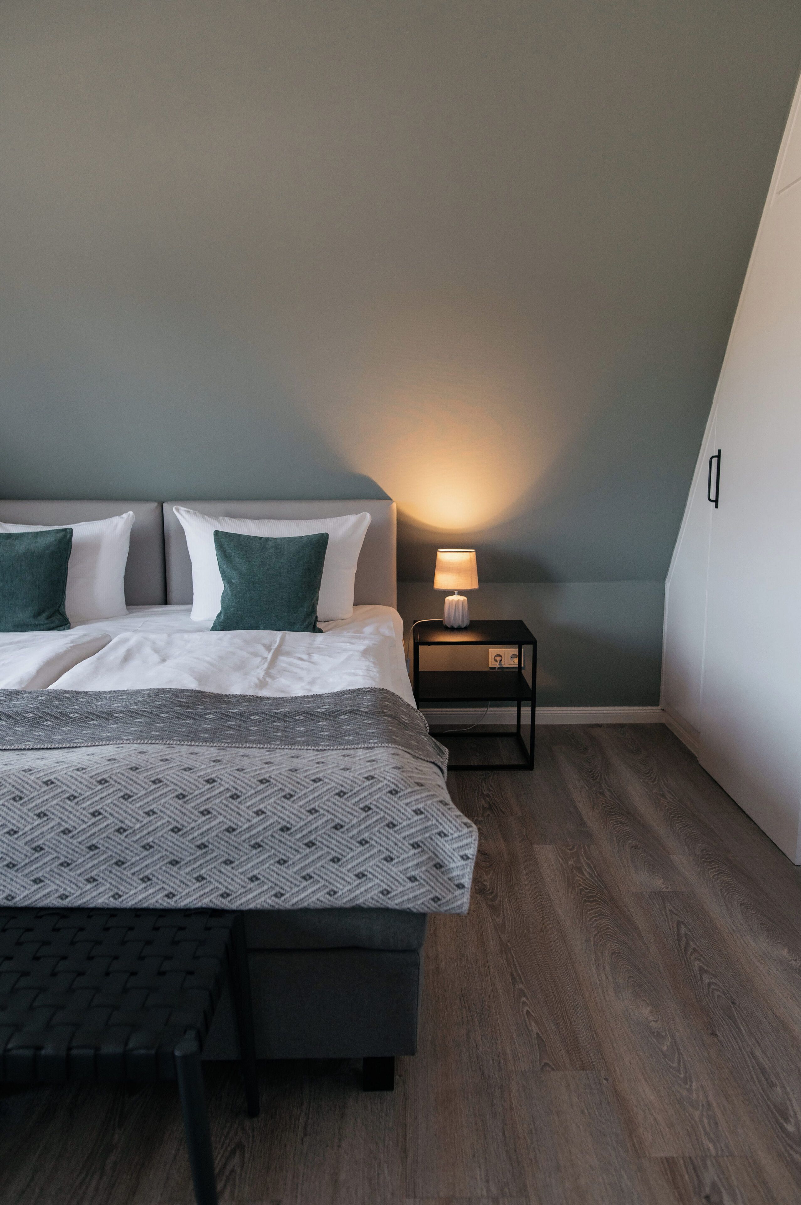 A bedroom with a bed, bedside tables, and a nightstand.