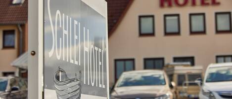 Un letrero de hotel con diseño moderno, que presenta un pájaro estilizado y la palabra 'HOTEL' en grande.