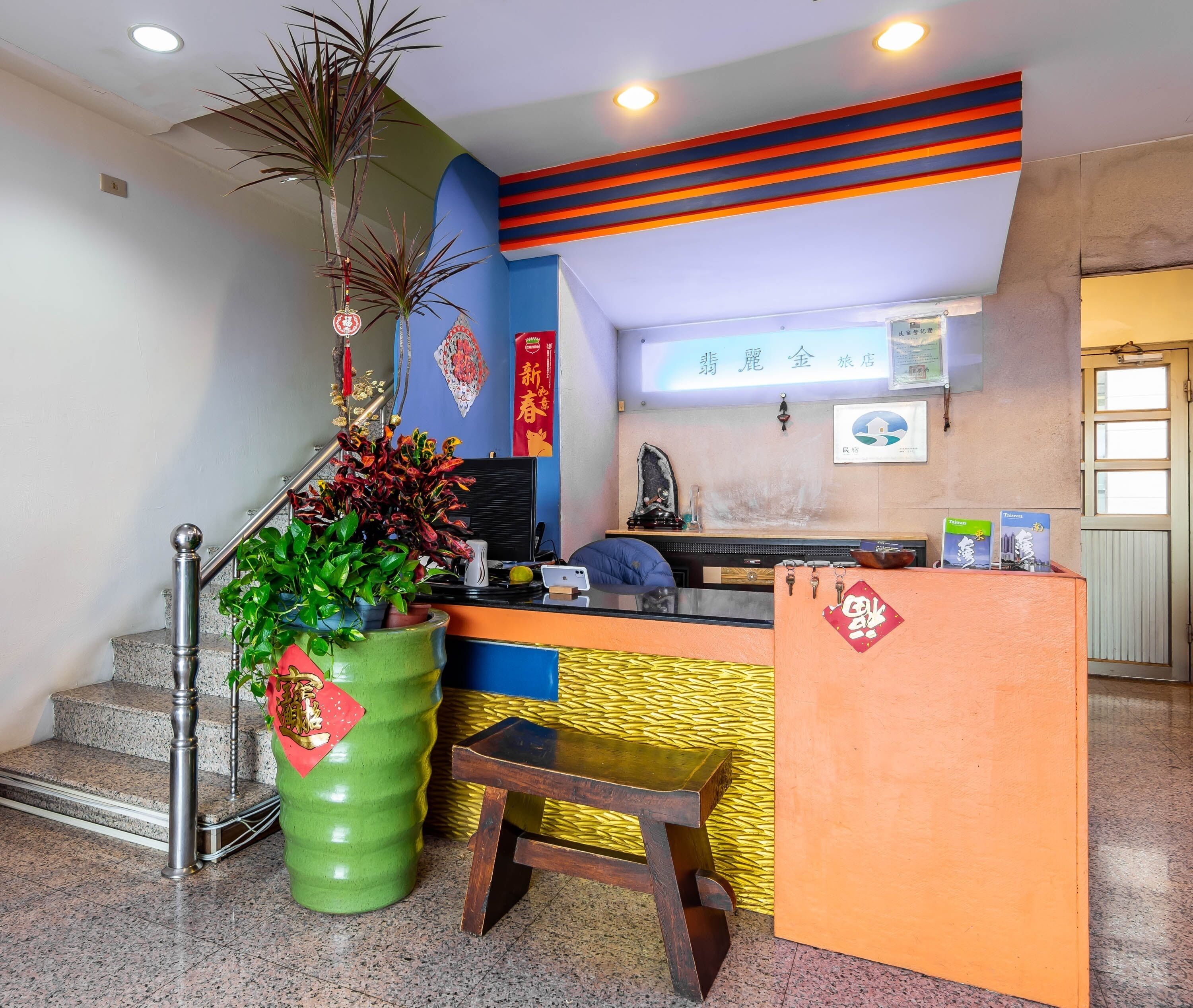 A reception area with a counter, a staircase, and a wall with decorative elements.