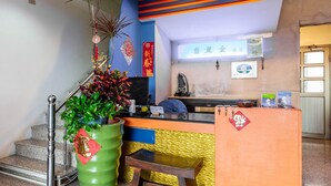 Un espace d’accueil comprenant un comptoir, un escalier et un mur agrémenté d’éléments décoratifs.