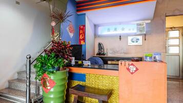 A reception area with a counter, a staircase, and a wall with decorative elements.