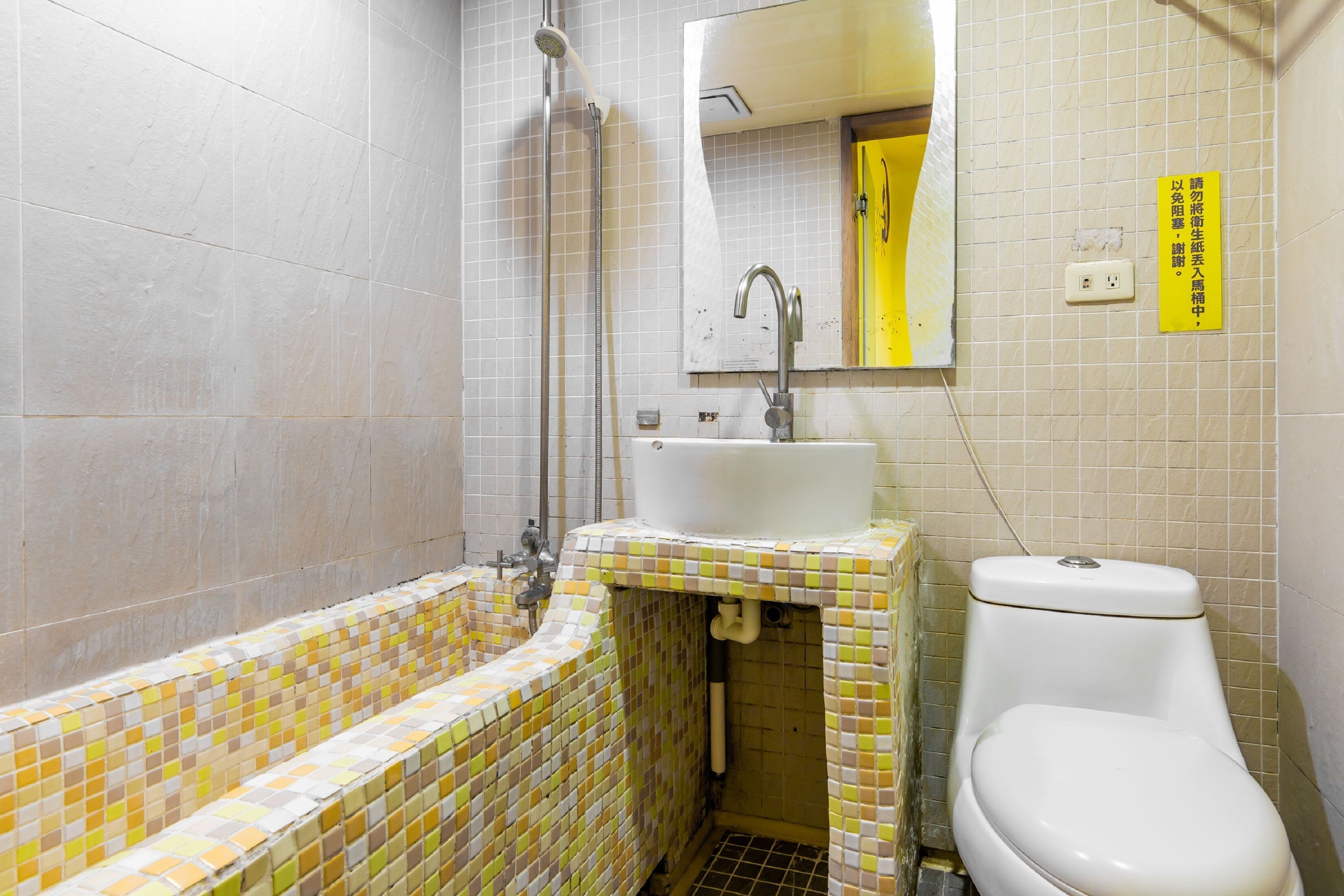 A bathroom with a tiled floor, a sink, a toilet, and a shower.