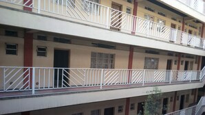 A multi-story building with balconies, windows, and doors.