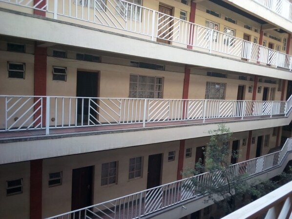 A multi-story building with balconies, windows, and doors.