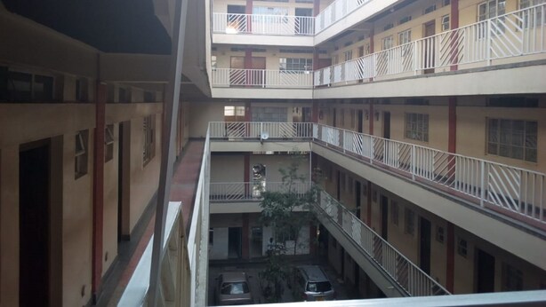 A multi-level atrium with balconies, a central courtyard, and a car parked in the lower level.