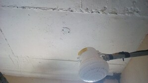 A ceiling with a visible hole and a water pipe.