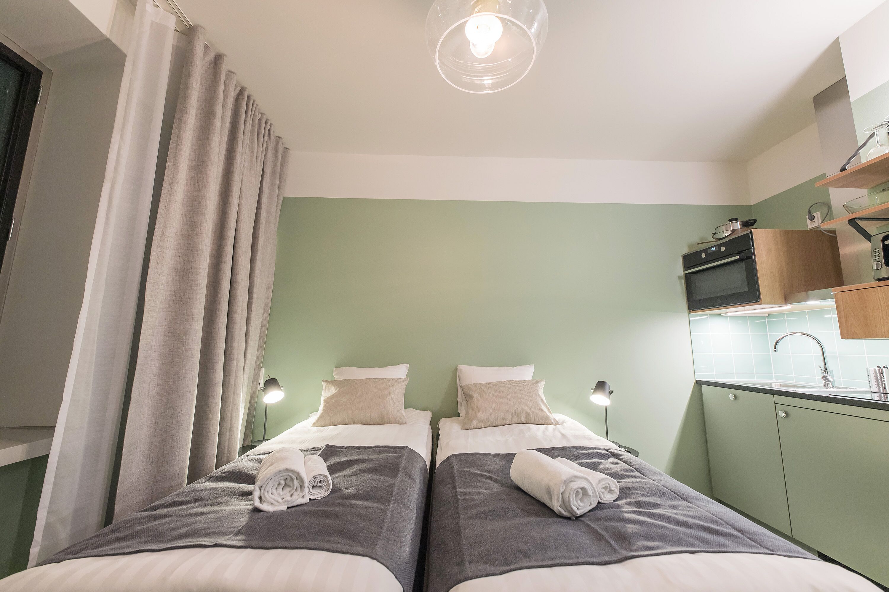 Ein Schlafzimmer mit zwei Betten, einer Küchenzeile und einem Badezimmer.