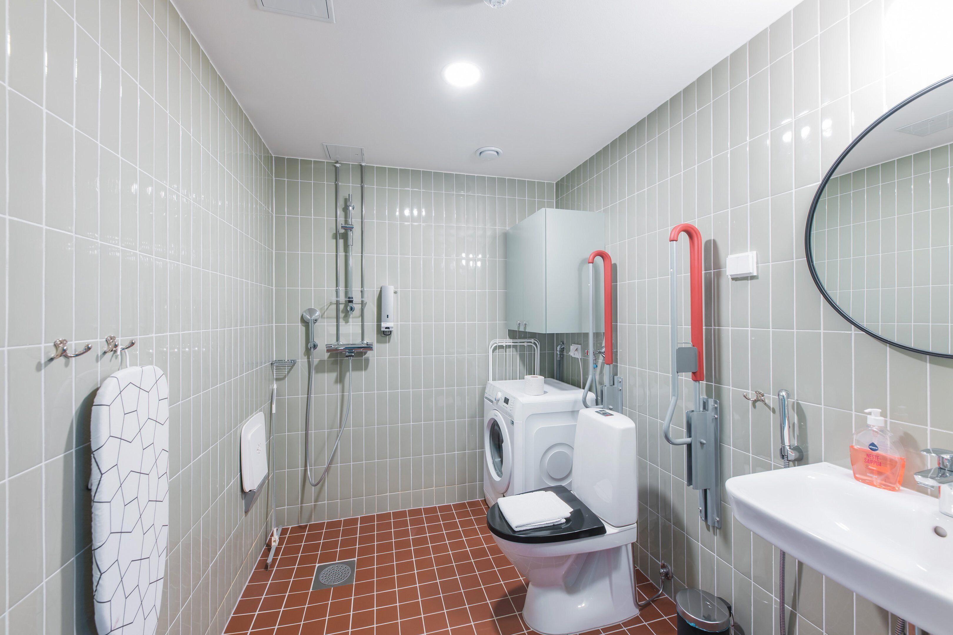 A bathroom with a washing machine, toilet, and sink.