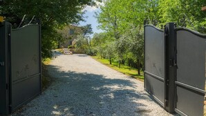 A gravel driveway leading to a stone building with a staircase. - Ai Due Cuori 4, Emma Villas (Capannori)