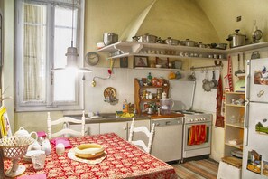 Classic kitchen with a dining table, stove, oven, and sink, perfect for cooking and dining.