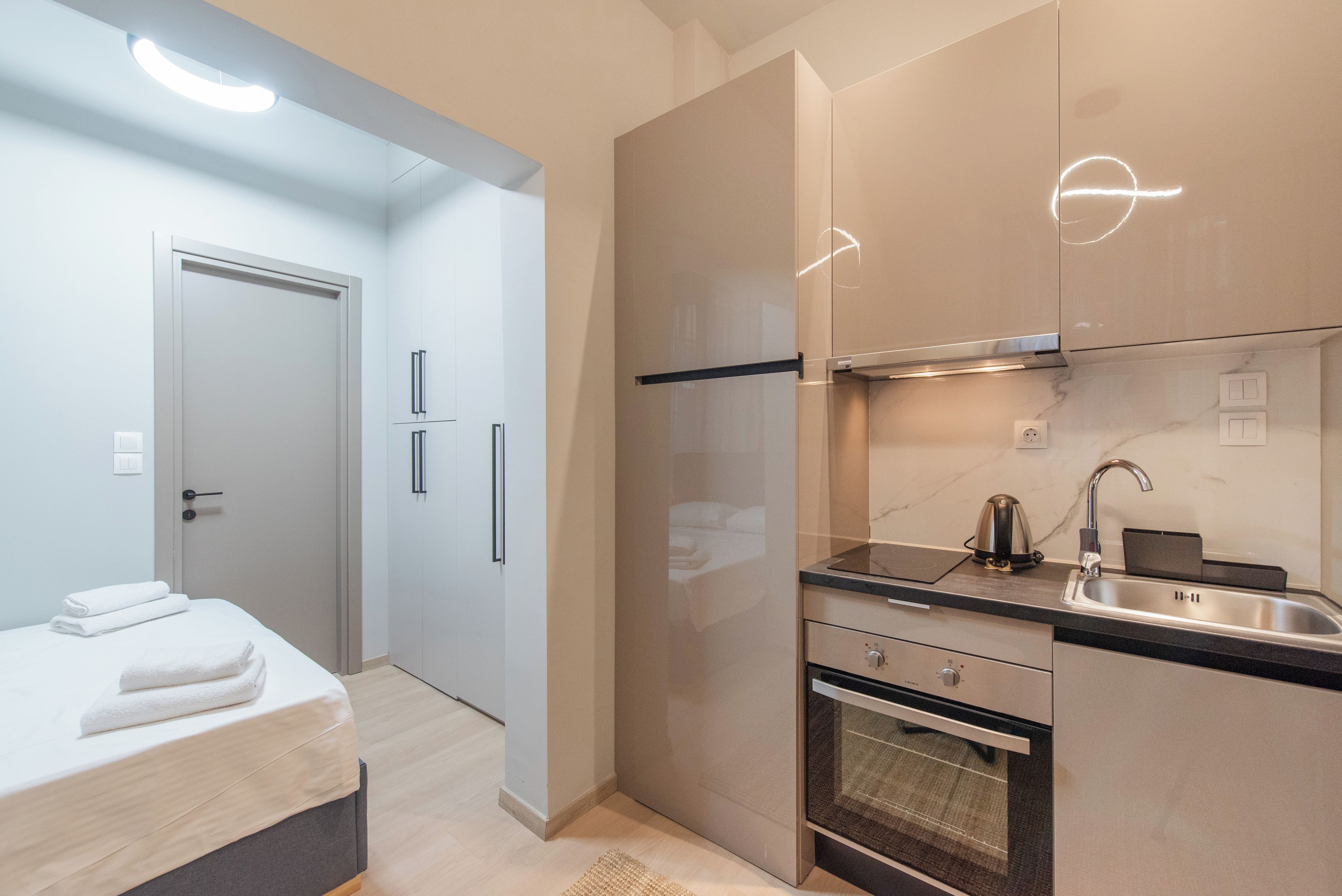 Una cocina moderna con horno integrado, un lavabo y un hervidor.