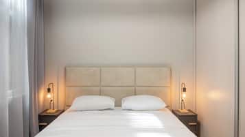 A hotel room with a large bed, two bedside tables, and a headboard.