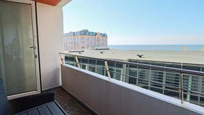 A balcony with a view of a beach and a building. - Haus am Meer App. 034 <br>"Togetherness by the sea" (Westerland)
