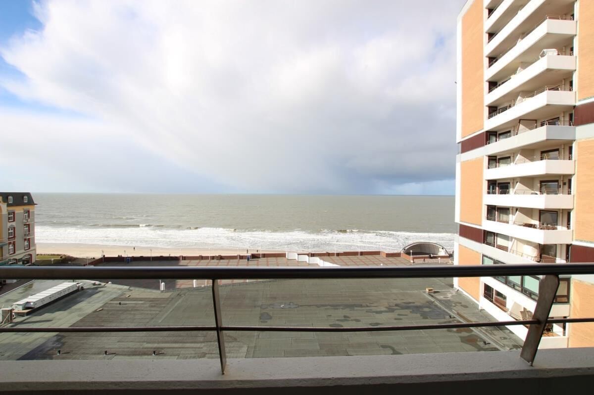 Un edificio alto con balcones que dan a la playa.