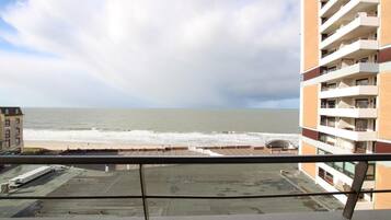 Un edificio alto con balcones que dan a la playa.