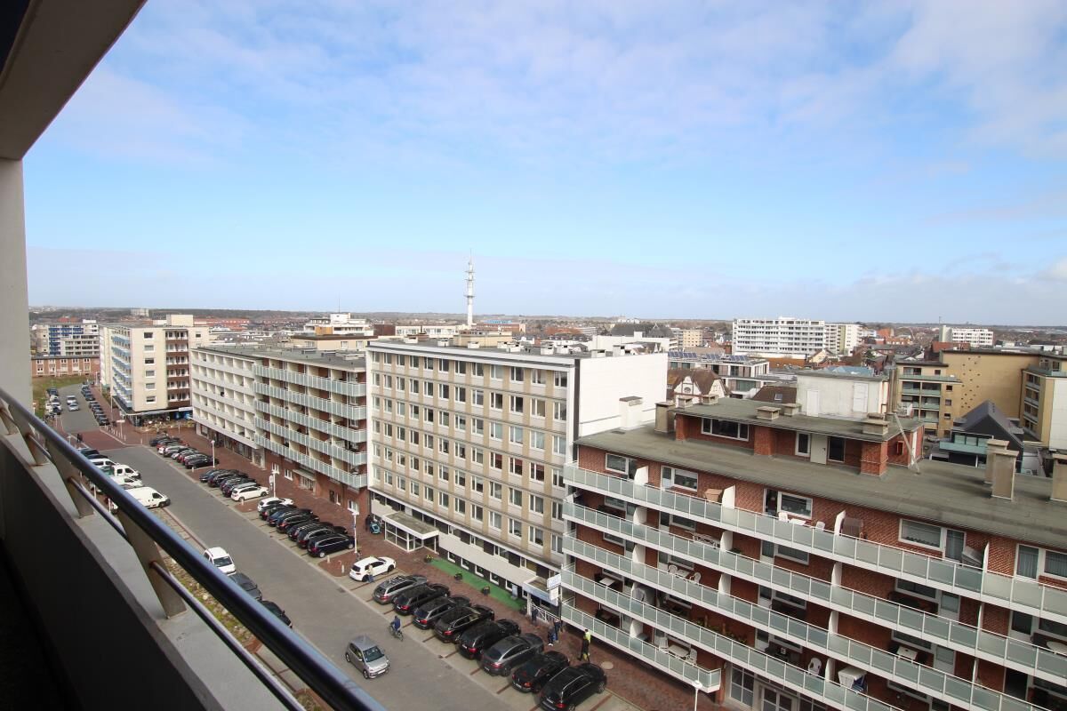 A multi-story building with a parking lot in front.