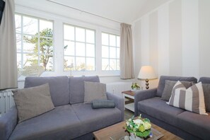 Relax in this inviting living room with two sofas, a coffee table, and a lamp, offering a comfortable space to unwind.