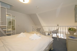 Relax in a spacious room with a large bed, desk, and balcony offering a view.