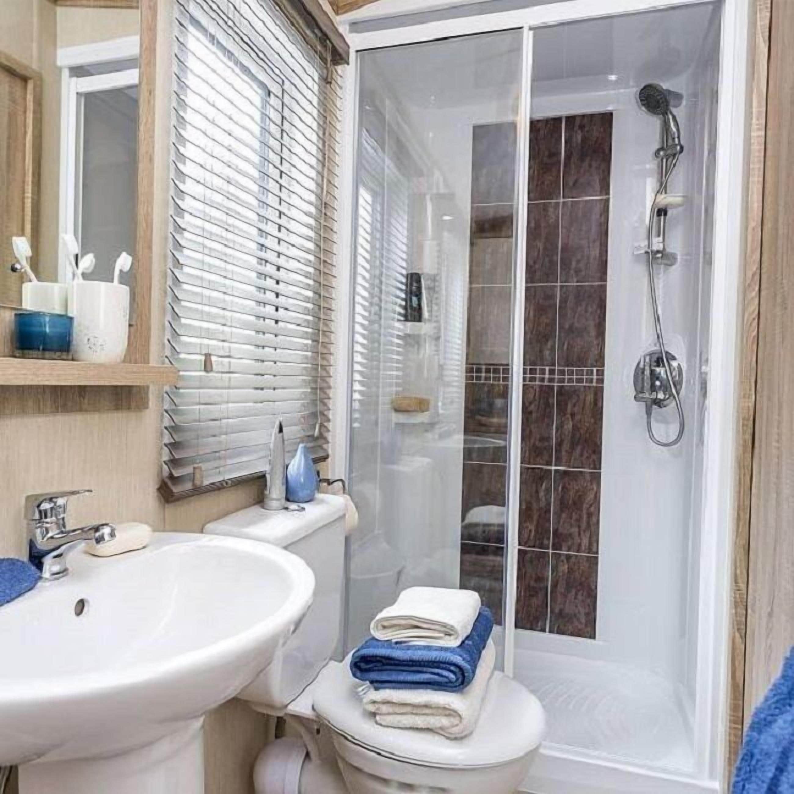 Een badkamer met een douchecabine, een wastafel en een toilet.