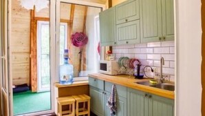 A kitchen with green cabinets, a patterned floor, and a small wooden stool. - Hostel Tarnopil (Ternopil)