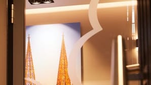 A framed picture of a cathedral with two spires, likely a Gothic style, in a modern interior setting. - Boutiquehotel am Stadtgarten (Freiburg im Breisgau)