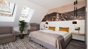 A modern bedroom with a bed, a sofa, a potted plant, and a cityscape mural on the wall.