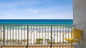 Un balcon avec vue sur une plage et l’océan.