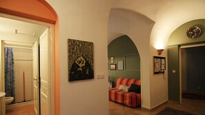 Um corredor com um sofá listrado, um quadro e um tapete.