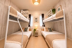 A room with bunk beds, a small bedside table with a lamp, and a plant. -  Grandioso Okinawa Villa Onna 5 (Onna)