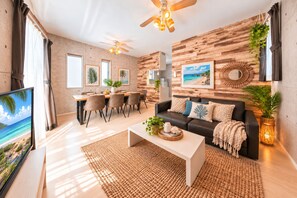 A modern living room with a sofa, coffee table, and dining area. -  Grandioso Okinawa Villa Onna 5 (Onna)