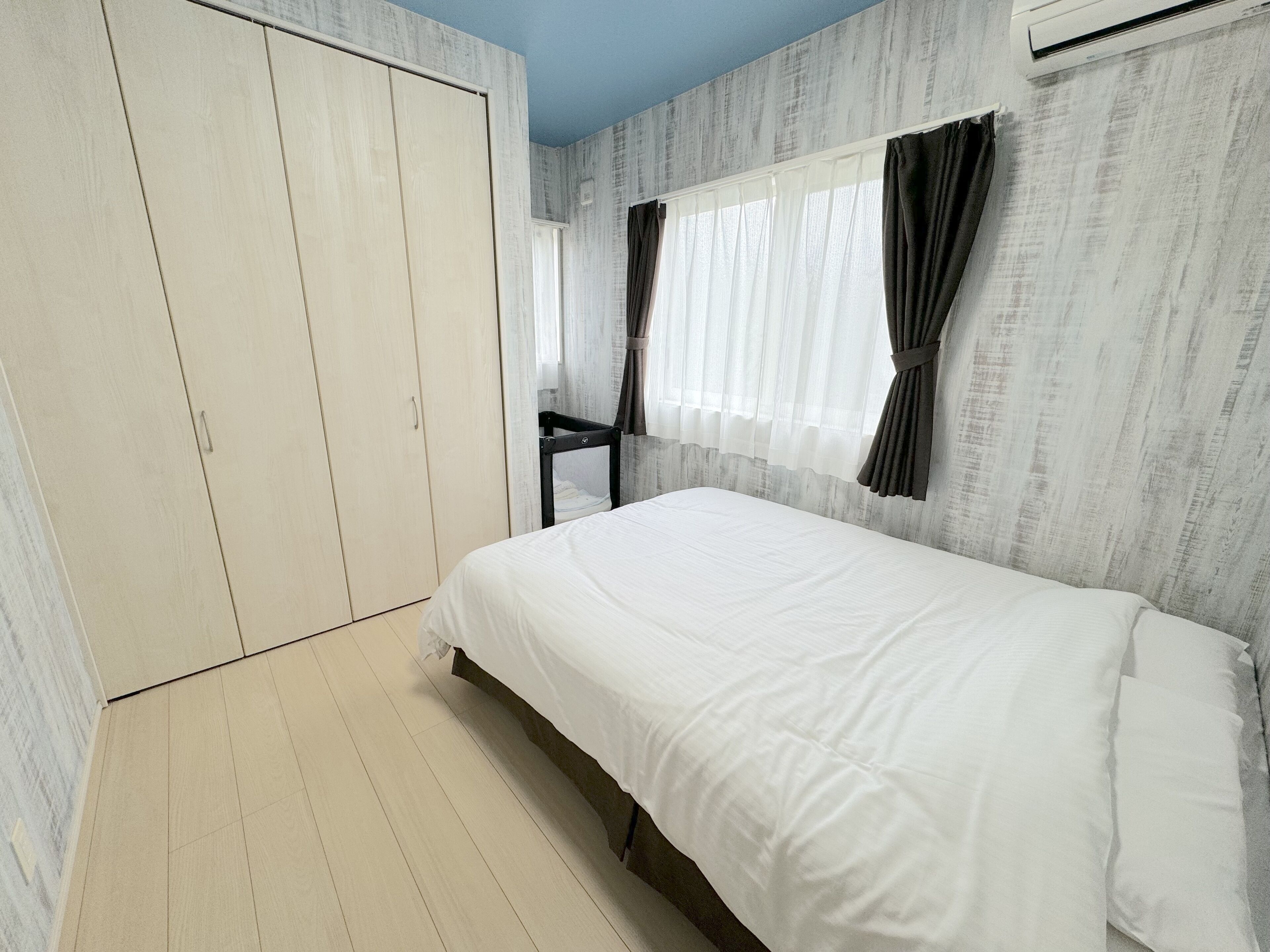 A bedroom with a bed, wardrobe, and a desk.