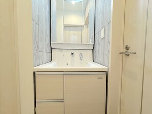 Un baño con lavamanos, espejo y mueble.