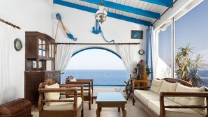 A room with a view of the sea, wooden furniture, a ship's wheel, and a blue and white color scheme. - Seafront Aegeans blue pearl over infinity pool (Keratea)