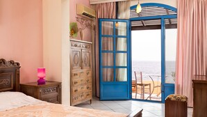 A bedroom with a bed, dresser, and a view of the sea through an open door. - Seafront Aegeans blue pearl over infinity pool (Keratea)