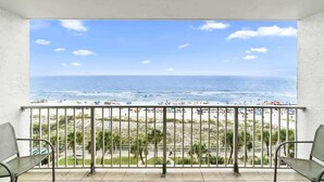 Uma varanda com vista para a praia e o oceano.