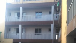 A multi-story residential building with balconies, a visible staircase, and a green flag on one of the upper floors. - Haridge Inn (Nairobi)
