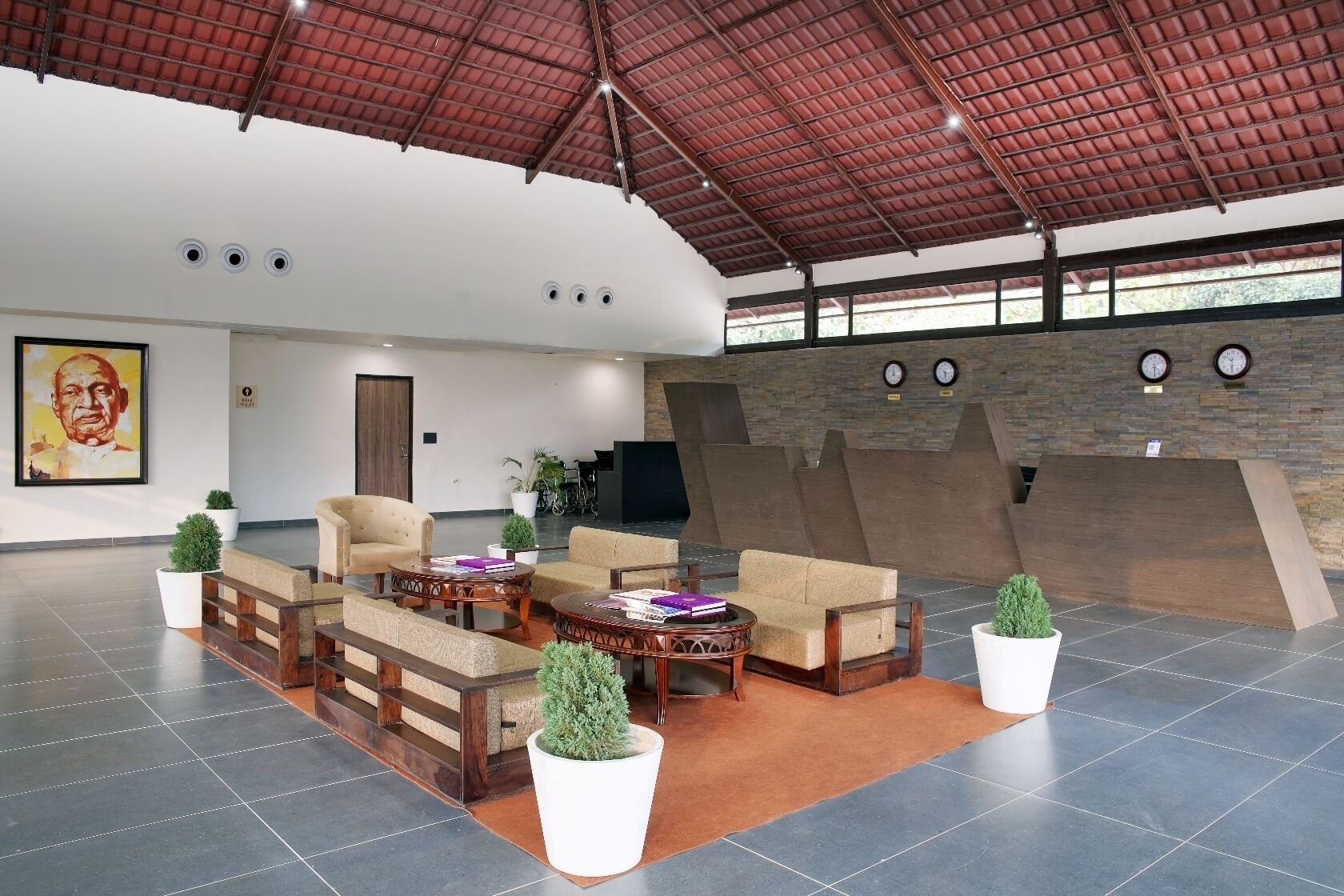 A spacious lobby with modern furniture, a high ceiling, and a large window.