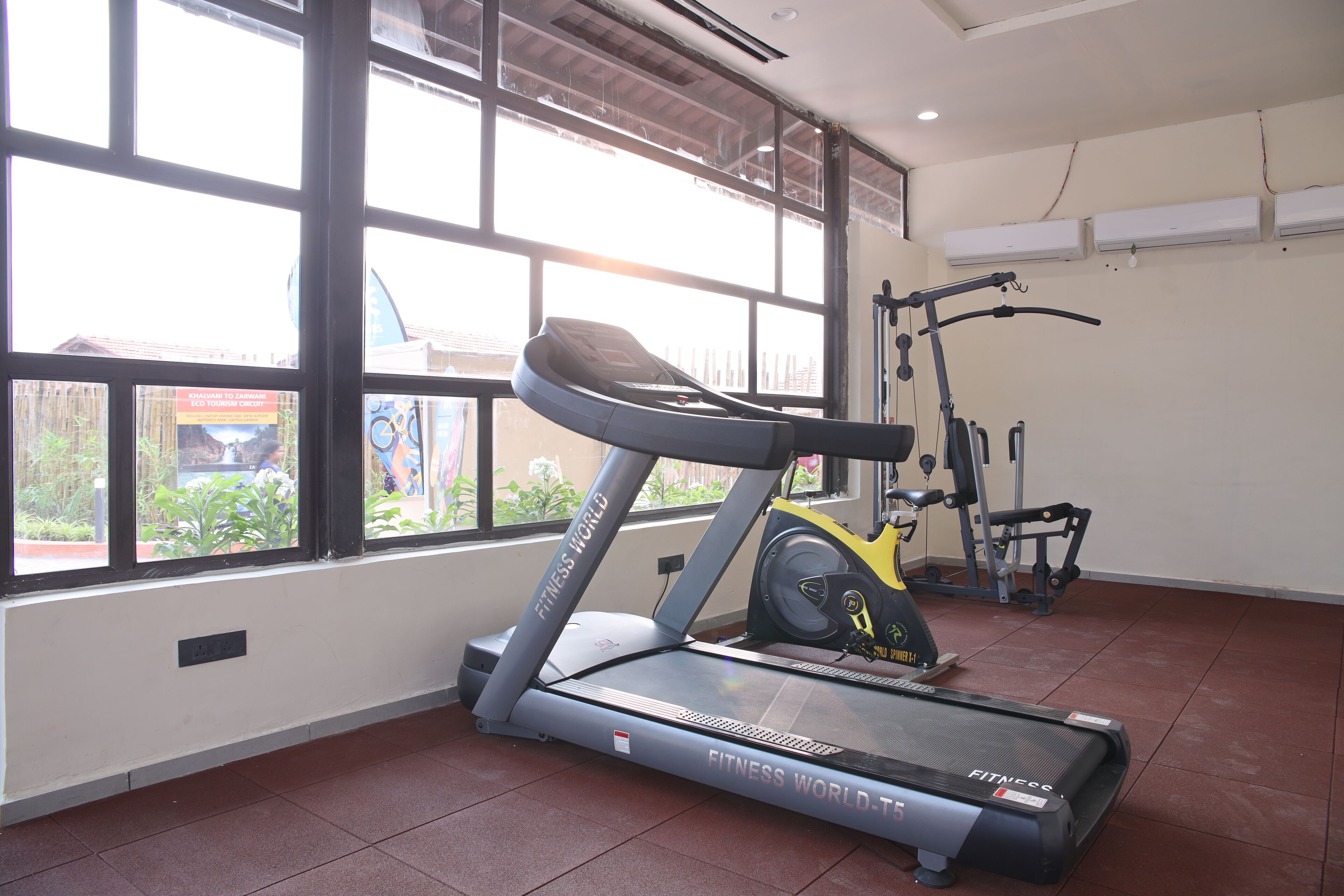 A fitness room with a treadmill, exercise bike, and weights.