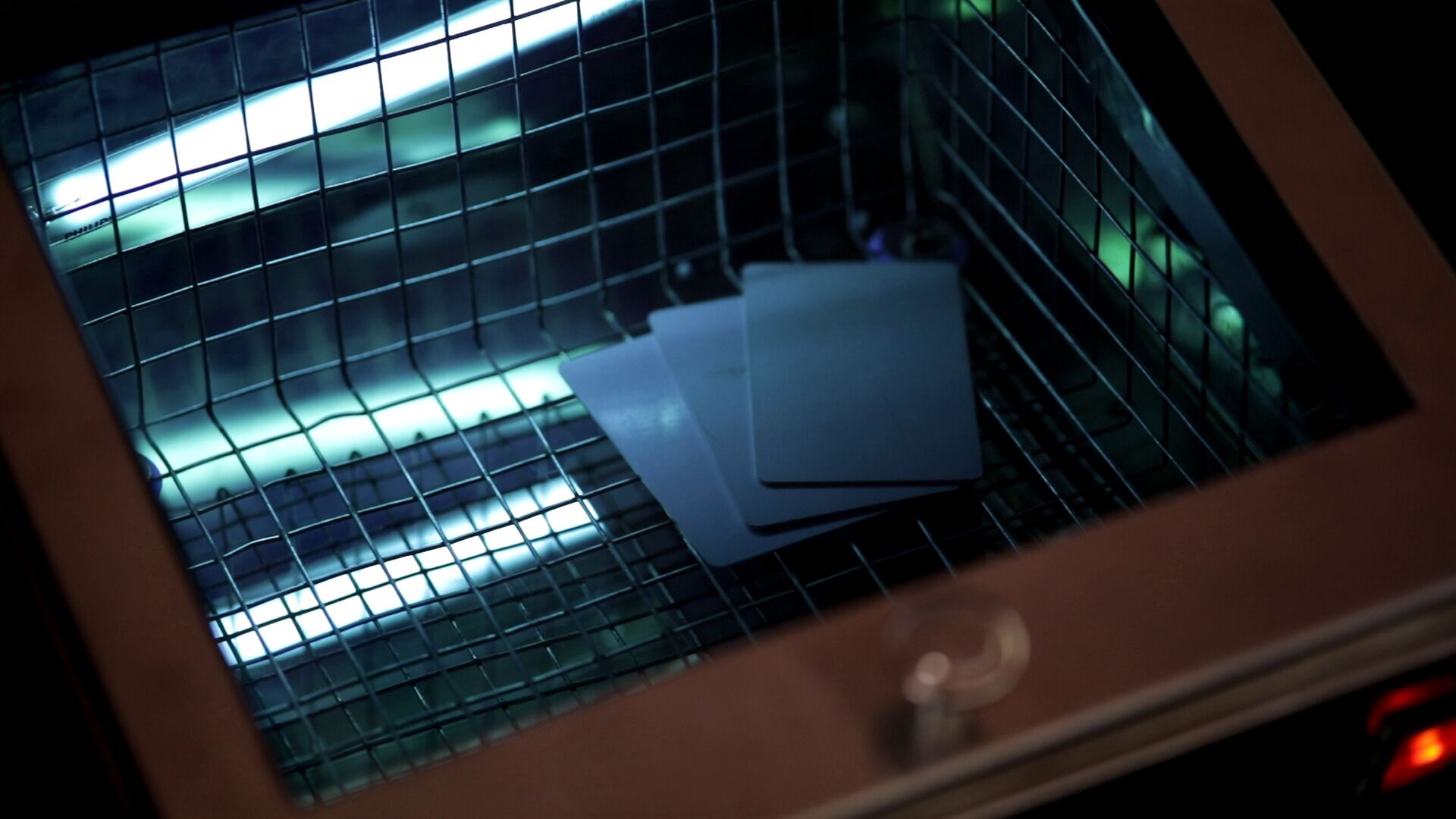 A close-up of a window with a grid pattern, through which a stack of papers is visible.