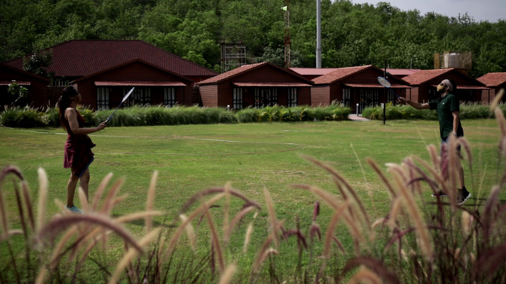A grassy field with buildings in the background.
