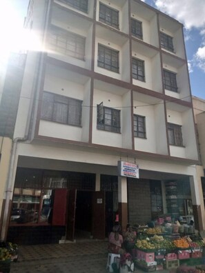 A multi-story building with a signboard advertising a hotel and catering services. - Sir James Hotel (Nairobi)