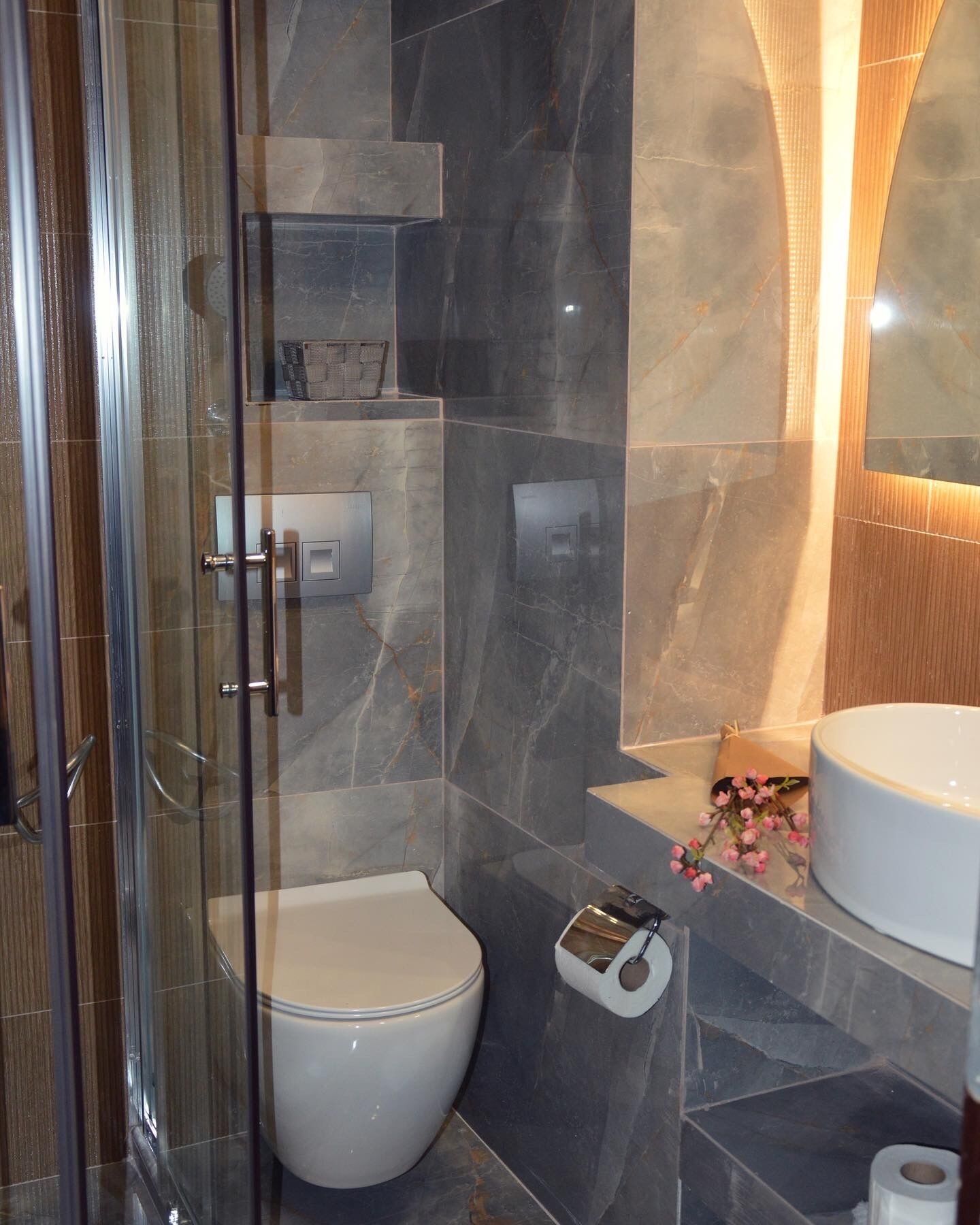 Un baño moderno con cabina de ducha de vidrio, inodoro y lavabo.