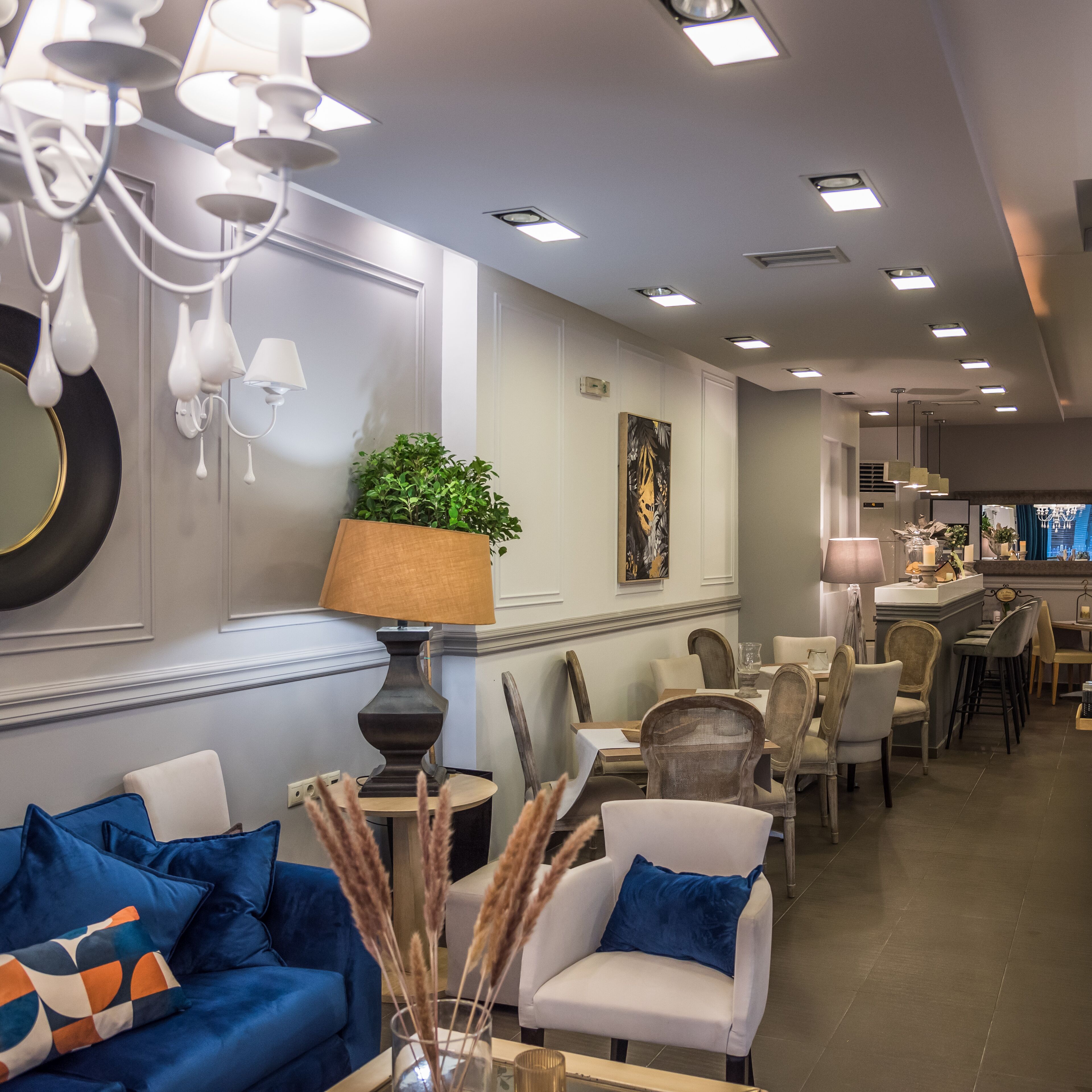 A modern hotel lobby with a seating area, a bar, and a dining space.
