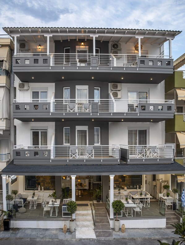 A multi-story hotel with balconies, outdoor seating, and air conditioning units. - Aqua Mare Hotel (Nea Propontida)