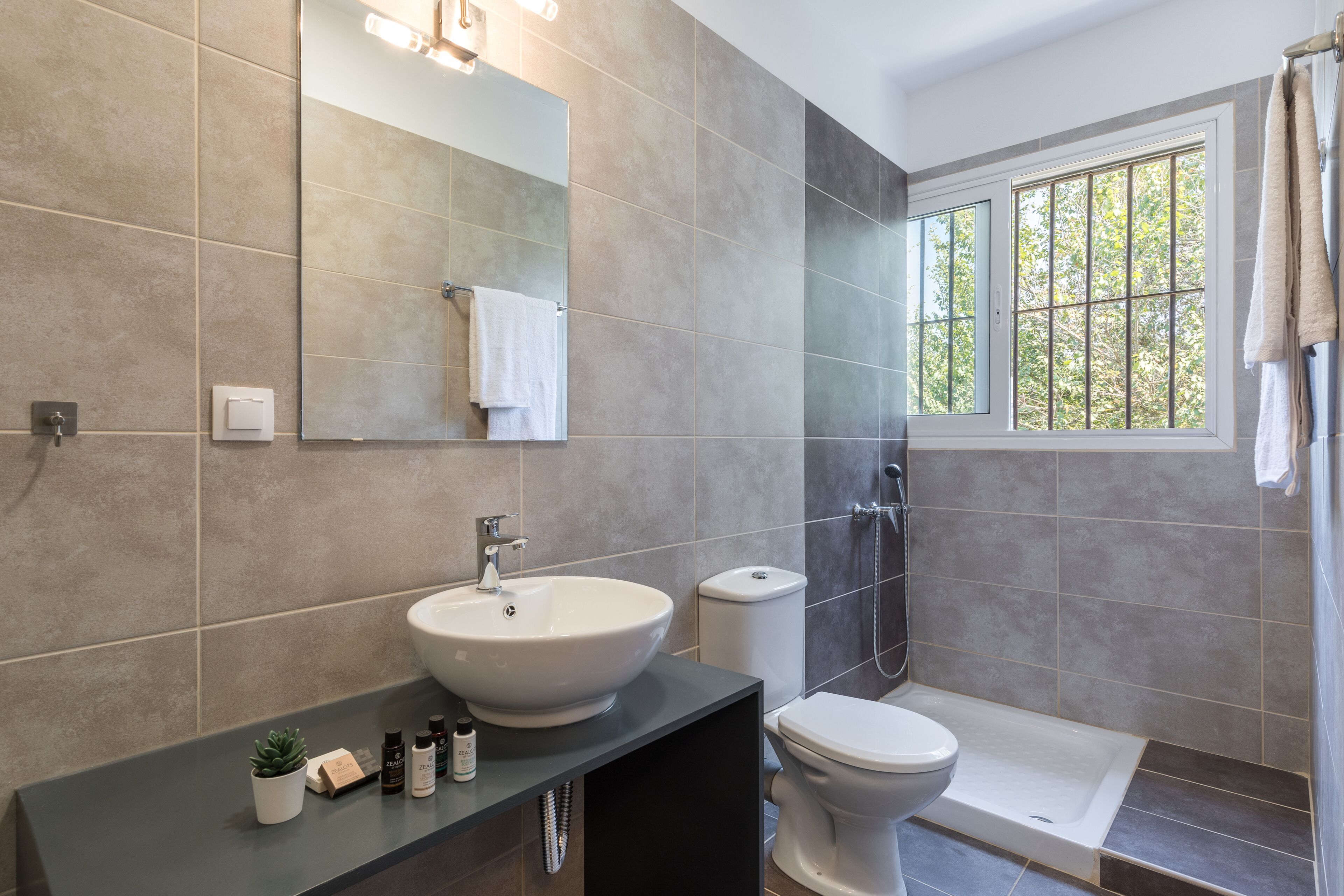 A modern bathroom with a large sink, toilet, and bathtub.