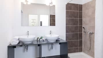 Slaapzaal | Badkamer | Een douche, een haardroger, handdoeken, zeep