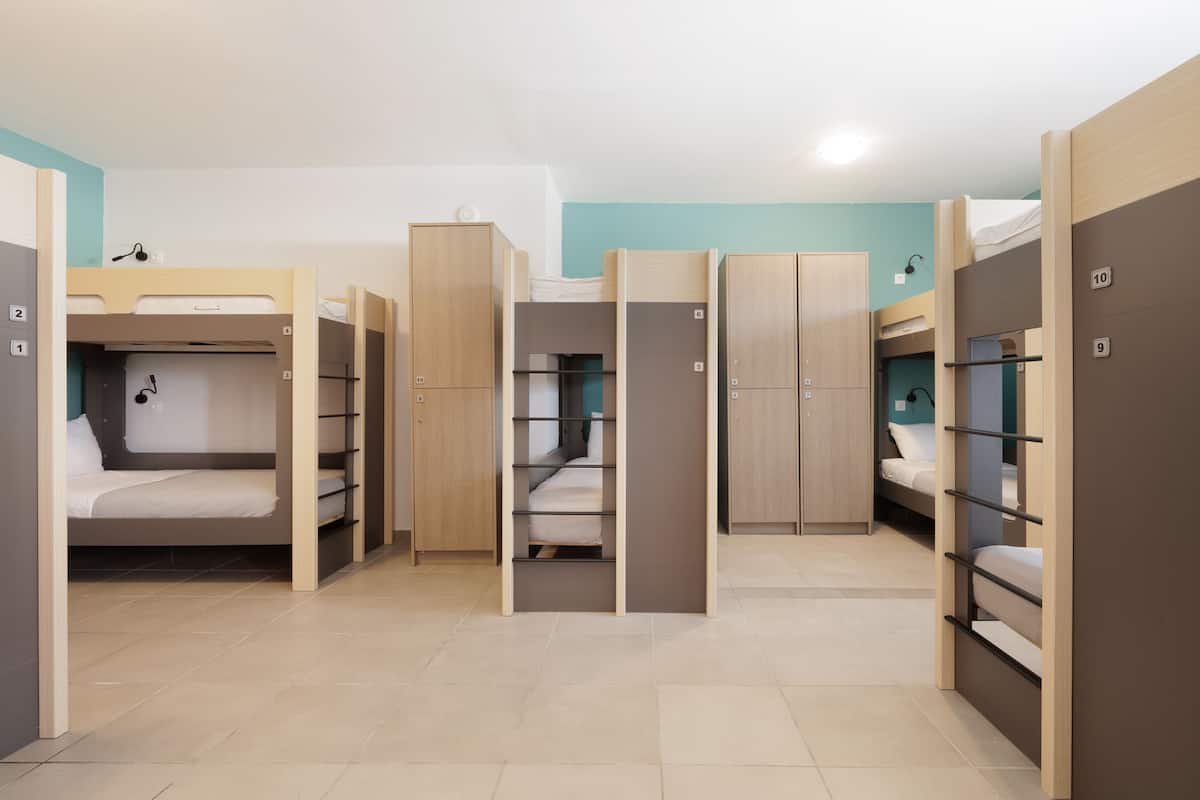 Un dormitorio con literas, armarios de madera y suelo de baldosas.