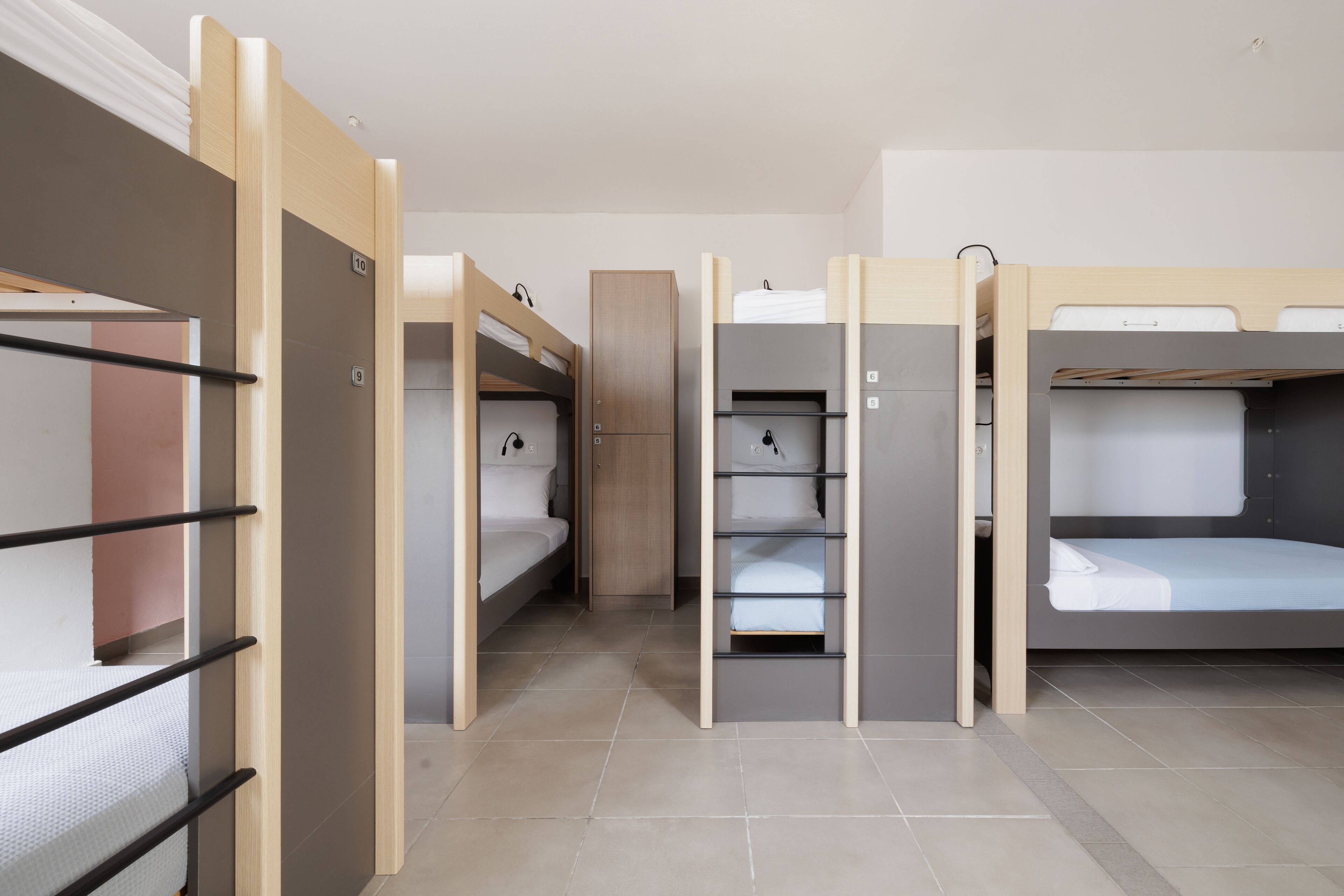 A room with bunk beds, a wardrobe, and a shelf unit.