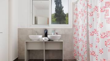 Une salle de bain moderne avec deux lavabos, un miroir et une fenêtre.